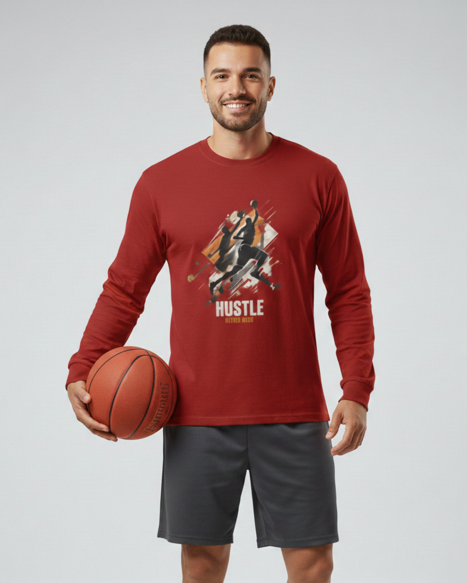 Man wearing a red long-sleeve shirt with a graphic design and text, holding a basketball on a plain background
